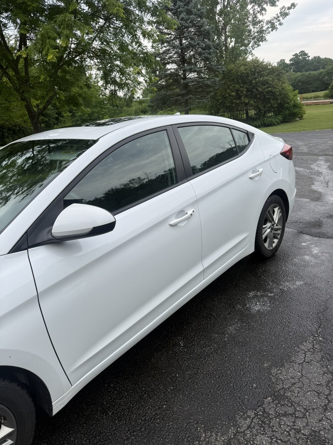 Glossy white sedan side profile after wash